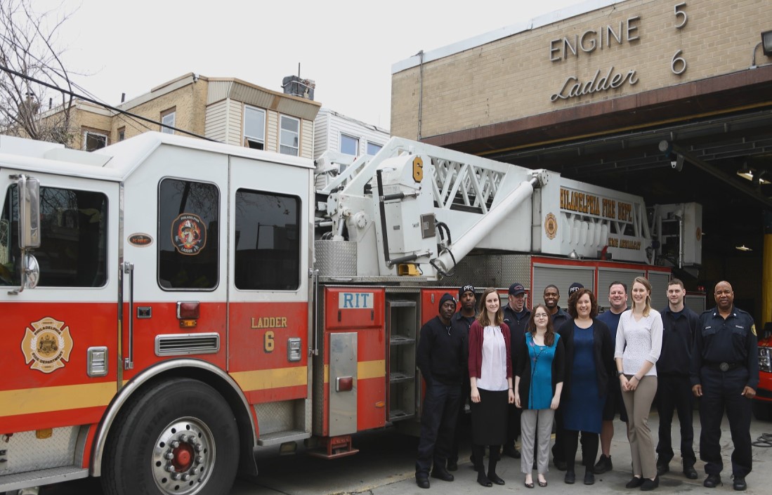 Group of individual standing next to a fire engine
